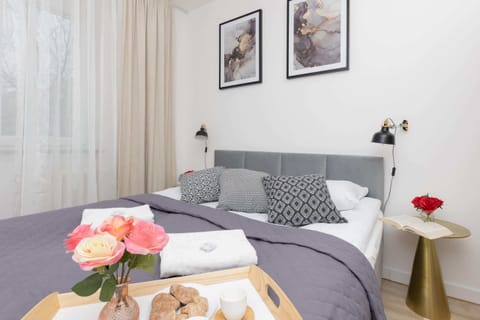 A stylish bedroom with a comfortable double bed, white furniture, and charming decor.