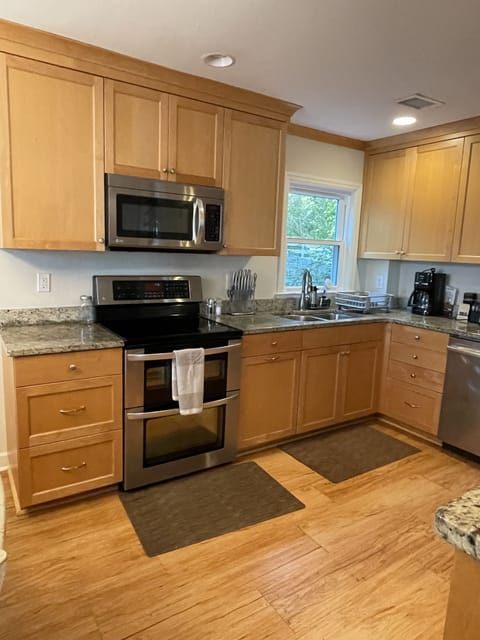 Kitchen view of oven and microwave and Cuisinart coffee maker.