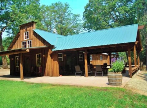 The covered back patio. There is a very large picnic table and the patio is surrounded with benches for plenty of seating and protection from the weather. 