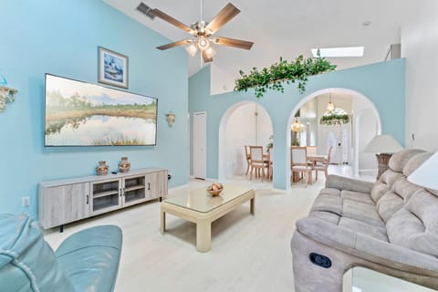 Bright living room w/ a new 75-inch Roku Smart TV and reclining couches.