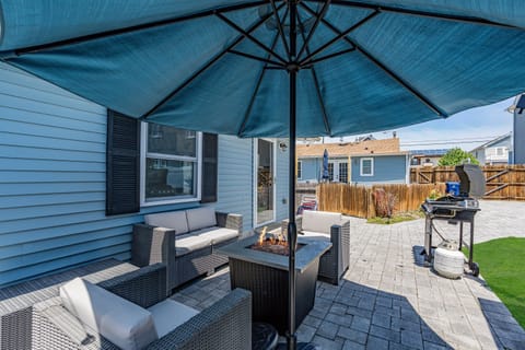 Settle in around the firepit table at golden hour. The umbrella stays up, the night gets long, the wave-sound carries from three blocks away.