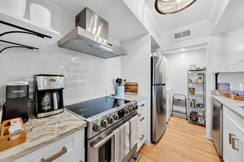 Gorgeous kitchen, a gourmet cooks dream! Stainless steel appliances, subway tile backsplash, and floating shelves. The pantry sits at the end of the kitchen and has a stacked washer and dryer.