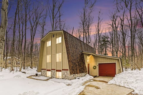 Snowy exterior of Sugarloaf Chalet with wooded surroundings in Arcadia, Michigan