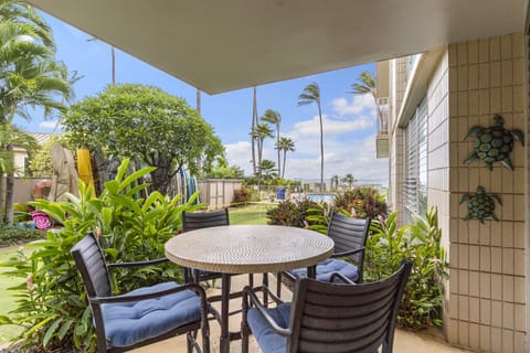 Ground level lanai with a view of the pool and swaying palm tree