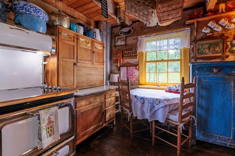 Dining table in kitchen. Kitchen is fully stocked with cookware, dishes, etc.