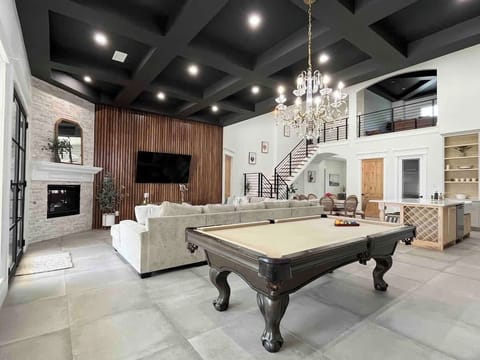 Luxury meets entertainment in this stunning open space! Play pool, relax by the fireplace, or lounge on the plush sectional. With soaring ceilings, a grand chandelier & stylish design, it's the perfect spot to unwind and make unforgettable memories!