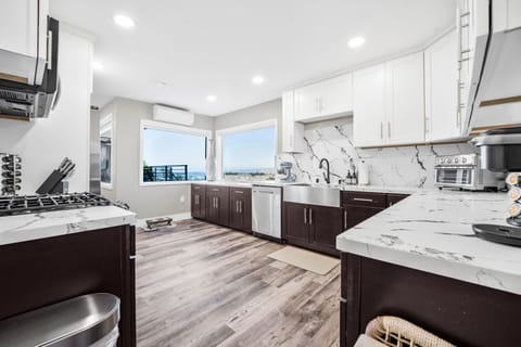 Large, open kitchen with updated appliances, stocked with cooking essentials. 