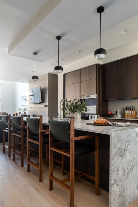 Your gourmet kitchen awaits with sleek marble countertops, modern pendant lighting, and a spacious island perfect for morning coffee or evening wine with friends