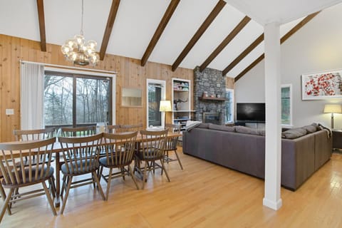 Open dining area seating 8 with vaulted ceilings and hardwood floors