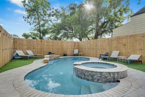 Beautiful outdoor pool w/ separate hot tub, back yard w/ artificial turf, outdoor seating, and bbq grill