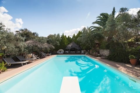 piscina con trampolino e solarium attrezzato con lettini , sdraio, ombrelloni