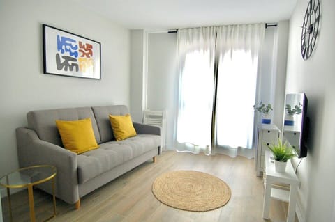 Salón comedor con gran ventanal por el que entra mucha luz natural / Living room with a large lookout window which lets plenty of sunlight in.