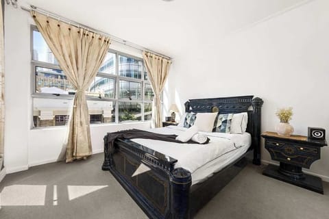 A large bedroom with a queen sized bed & plush pillows.