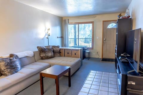 The open living room is a dynamic space perfect for relaxing with your group with a large sectional sofa, an entertainment center complete with a 60” TV, puzzles, and games, and an arcade table with games like Ms. Pac-Man and Donkey Kong.