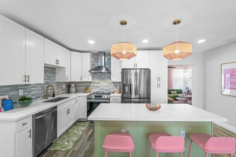 The brand-new chef’s kitchen is fully stocked with all of your cooking necessities and includes an island countertop, with 4 candy colored European bar stools.