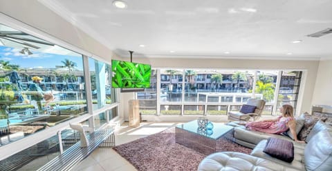 The spacious living room features outstanding views of the heated pool and waterway, a bar and a fire place.