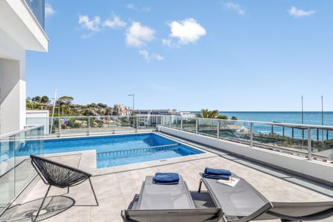 sunloungers and beach towels around the pool and a great sea view