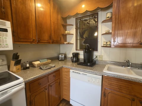 Kitchen, dishwasher, electric range and oven, microwave, toaster, coffee pots.