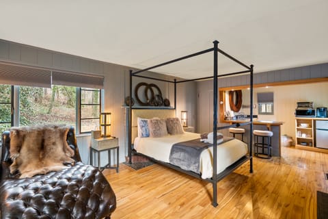 Main bedroom and living space with queen bed and leather chaise lounge 