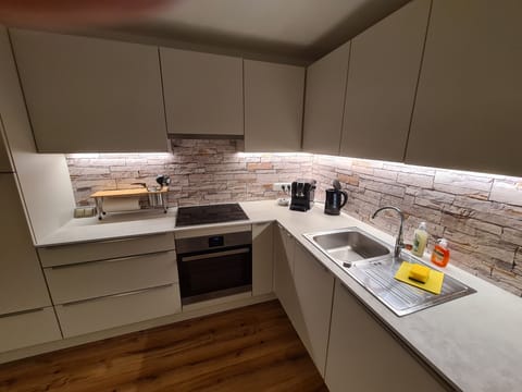 Arbeitsbereich mit Kaffeemaschine, Wasserkocher, Induktionsherd und Backofen