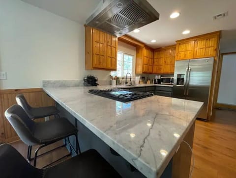 Fully stocked kitchen with white marble counter tops and breakfast bar