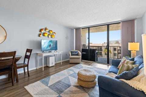 Unwind in this airy living room with ocean views! Cozy seating, a smart TV & balcony access make it perfect for relaxing
