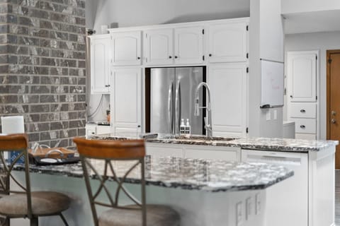 Your gourmet kitchen awaits with granite countertops, stainless appliances, and warm brick accents—perfect for creating memorable meals together.