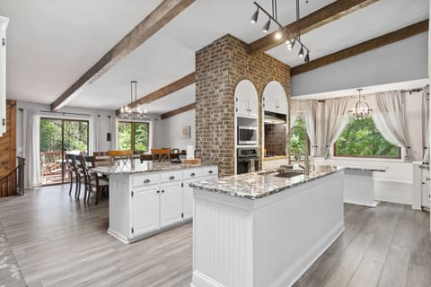 Your spacious kitchen features granite countertops, rustic beams, and brick accents creating the perfect gathering space for memorable meals.