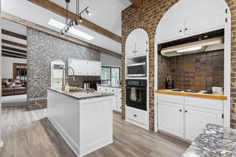 You'll love preparing meals in this stunning chef's kitchen, featuring exposed brick arches, granite countertops, and modern appliances.
