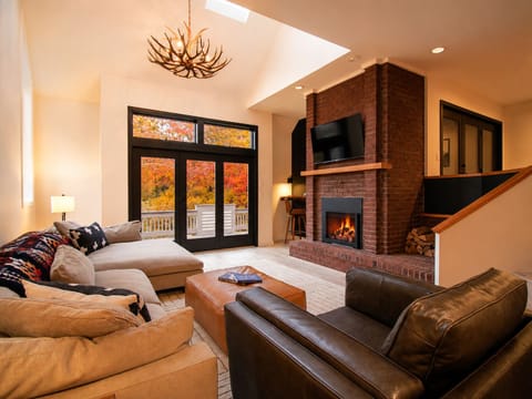 Fall living room with gas fireplace and foliage views.