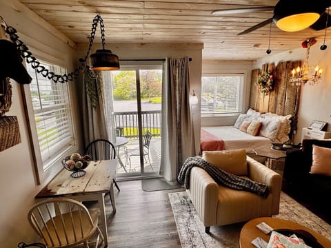 Open- concept  living, dining, and sleeping loft with farmhouse table and balcony access