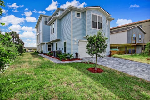Charming coastal home with a private driveway and manicured front yard just steps from the beach.
