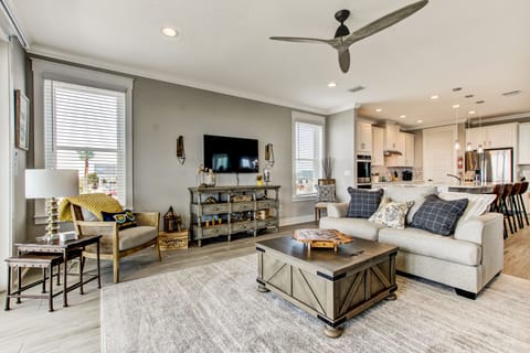 - Open living room with plush seating, wall mounted TV, & chic décor accents
- Stylish rustic wood tables & layered textures make the space feel relaxed & refined
- Seamless layout flows into the kitchen, perfect for group hangs and cozy evenings in
