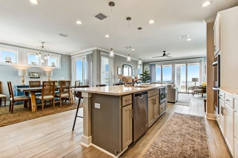 - Enjoy ocean peeks from a chef’s kitchen with dual tone cabinetry, deep island, and exclusive finishes
- Full dining table and inviting lighting make meals extra special
- Wide layout ensures flow from kitchen to balcony and beyond
