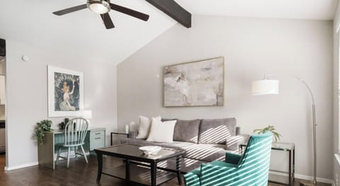 Large and open living room with sleeper sofa, smart tv, and work desk