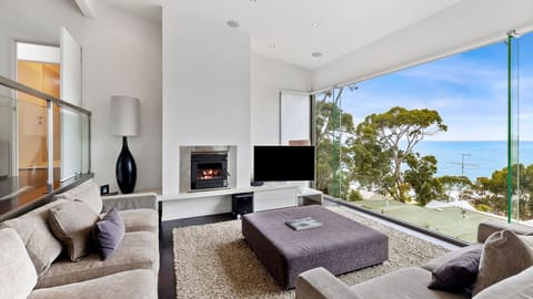 The upstairs living room has stylish furnishings and a fireplace to keep you cosy. 