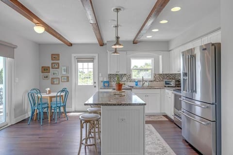 - Bright white kitchen features granite countertops, stainless steel appliances
- Center island includes barstool seating for casual bites or conversation
- Small café table by the door is perfect for coffee or breakfast