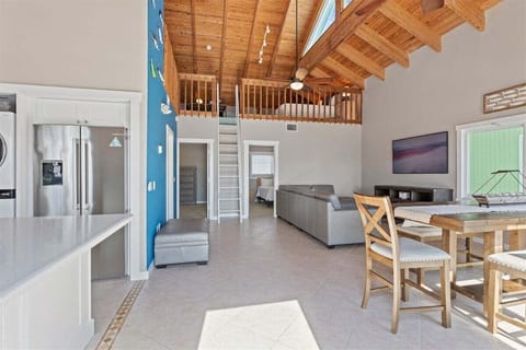 Airy elegance: Open-concept living, kitchen, and dining area beneath soaring ceilings.