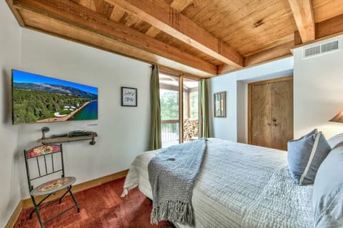 Primary bedroom king bed, en suite bath and deck looking out to wooded meadow.