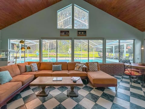 Spacious and beautiful living room with Large screen TV and outdoor view of property and pool