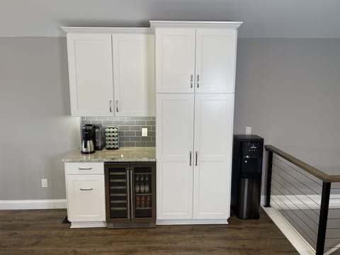 The coffee bar, beverage fridge, hot/cold water dispenser, and pantry. 