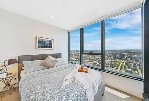 The master bedroom with a queen sized bed & plush pillows.