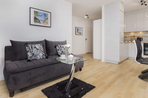 Spacious living room with a sofa and a large window, offering natural light and a cozy ambiance.