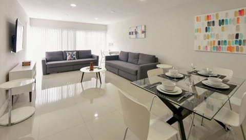 Open living and dining area with sofas, table, and wall art