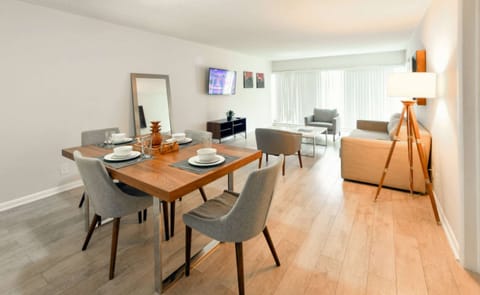 Open dining and living area with table, sofa, chairs, and TV