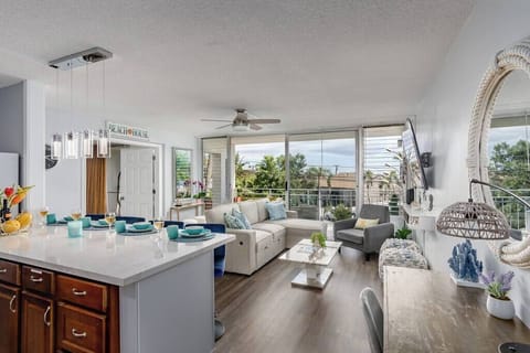 A spacious and open kitchen that looks out into a tastefully decorated living area with a pullout couch and plenty of seating.  A desk is also in the perfect place so that our guests can work and visit with their family at the same time!