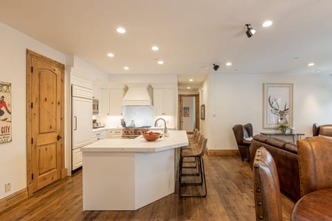 Fully equipped kitchen space featuring stainless steel appliances, gorgeous stone countertops, and bar seating for four