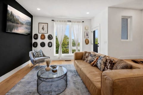 Sunlit living space with mounted smart TV, ideal for relaxation and group fun.