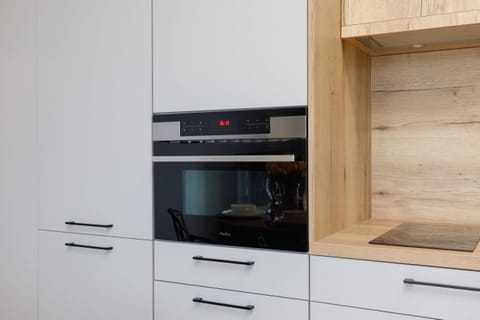 A kitchen with built-in appliances and natural wood accents.
