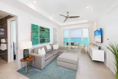 Modern living area with HD cable TV, sectional sofa, and walkout access to a private ocean balcony. 